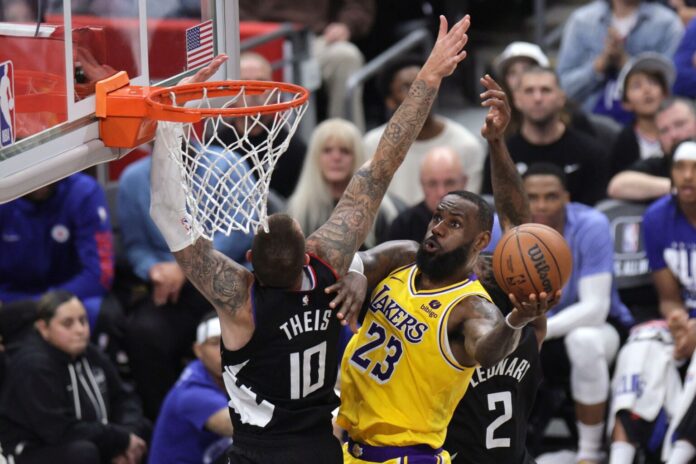 epa11187879 Los Angeles Lakers forward LeBron James (R) shoots the ball against Los Angeles Clippers center Daniel Theis (L) during the second half of the NBA basketball game between the Los Angeles Lakers and the Los Angeles Clippers in Los Angeles, California, USA, 28 February 2024.  EPA-EFE/ALLISON DINNER SHUTTERSTOCK OUT